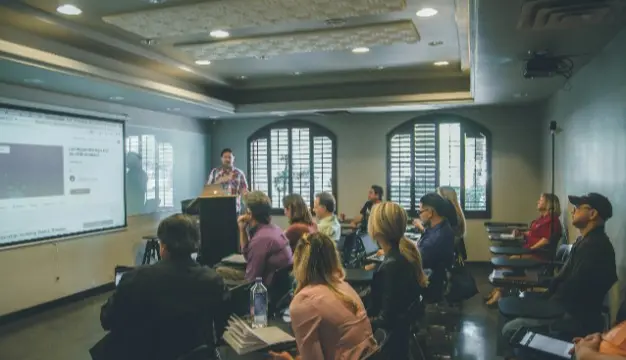 A group watching a product demonstration in a conference room, showcasing the benefits and features of the product.